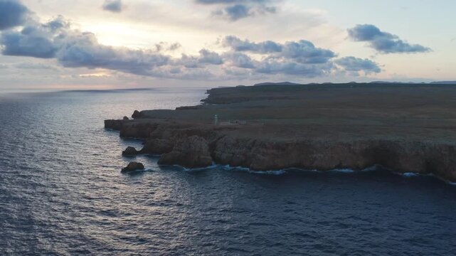 Aerial Panoramic View of Lighthouse at Sunset on Rocky Coastline, Punta Nati Menorca Mediterranean