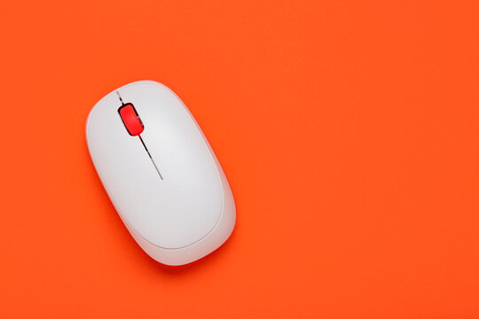 Modern wireless computer mouse on orange background