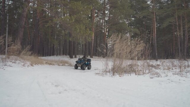 Atv turning toward camera on snow, spinning tire closeup with spinning tread, aggressive steering through pine edge, winter test run, high energy offroad footage for sport and commercial use