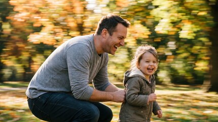 Fototapeta premium Happy father playing with his young daughter outdoors in autumn park setting.