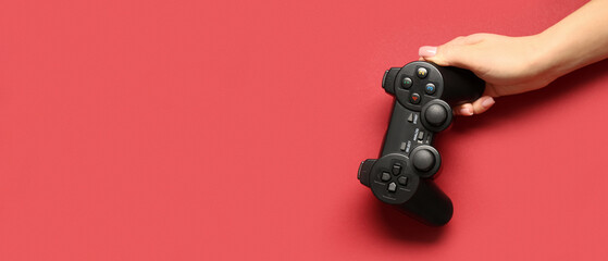 Female hand with modern joystick on red background, closeup © Pixel-Shot