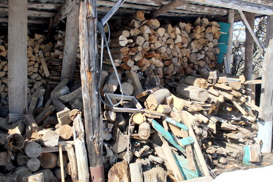 There is a shed with firewood outside.