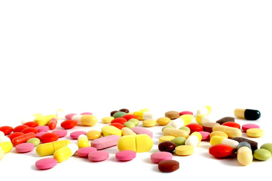 There is a pile of brightly colored pills on a white background.