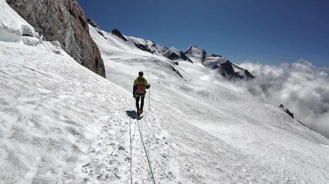 POV mountaineering in rope team with mountaineer and mountain panorama with summits Pollux and Castor on the glacier in summer in Pennine Alps, Italy