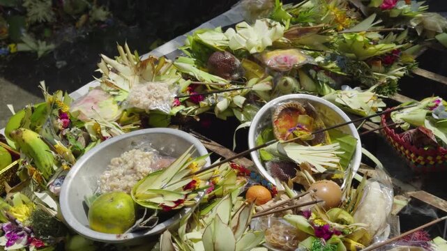 Close up of stacked Balinese canang offerings made from coconut leaves filled with flowers and incense. Represents daily Hindu prayer rituals, rich in culture, spirituality, and sacred tradition.