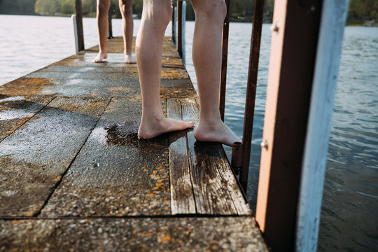 Kids wet feet on swimming dock during lake swim