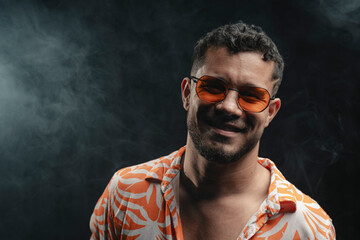 Obraz premium Man in orange sunglasses smiling with smoke