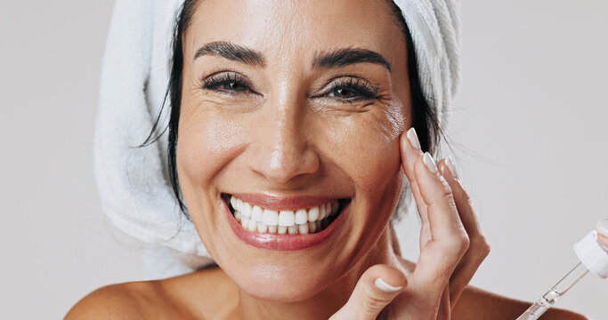 Skincare, portrait and woman with dropper in studio, hyaluronic acid treatment or anti aging product. Smile, glowing skin or mature person with wrinkle serum for hydration, beauty or white background
