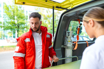Male paramedic in red uniform preparing a stretcher inside an ambulance with an oxygen tank visible. Emergency medical technician readying equipment for a patient. Healthcare and rescue concept. © Graphicroyalty