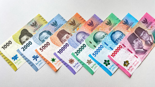 Colored Indonesian rupiah banknotes of various denominations on a light background. Concept of finance, cash, and the foreign exchange market.