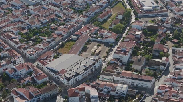 Drone view of cycling race passing through streets of Elvas city with urban landscape and rooftops Portugal