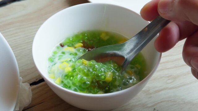 Thai Green Sago Coconut Milk Dessert Close Up - Traditional Asian Sweet Soup Pandan Tapioca Stirring Bowl