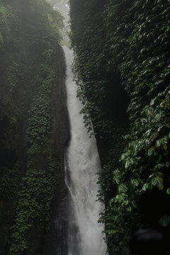 Multiple waterfalls cascading over mossy rocks at Sekumpul, Bali