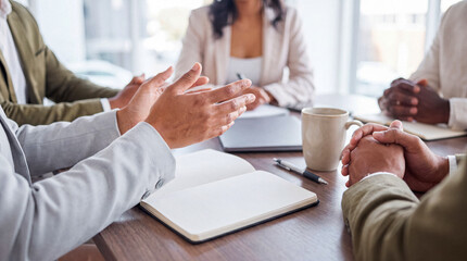 Close-up of diverse business colleagues actively discussing and gesturing during a productive corporate team meeting. © Pamela