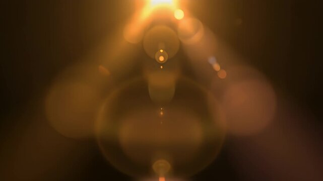 Golden lens flare effect on dark background abstract overlay