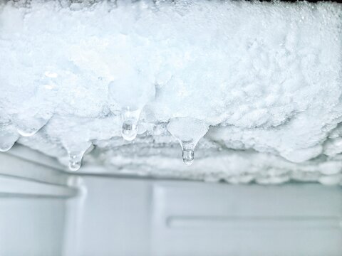 Close Up Frozen Ice Buildup Inside Refrigerator with Icicle Formation