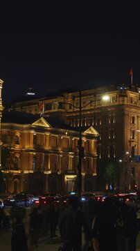 Panoramic View of Shanghai's Historic Riverfront with Crowds at Night
