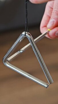 Slow Motion Close-up of Hand Playing Metal Triangle