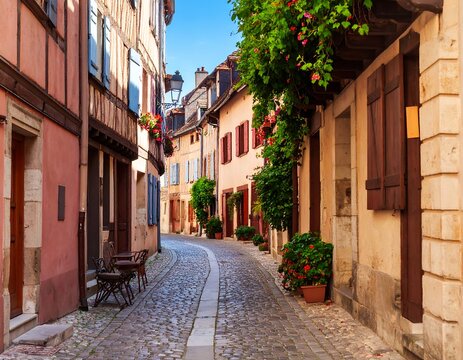 A winding cobblestone street in a quaint European town, lined with colorful buildings, flowers, and charming architecture