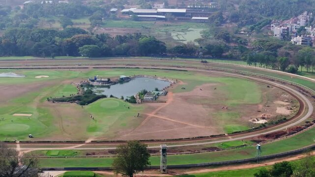 Mysore Race Course Horse Racing Track with Ground, trees and buildings at Mysuru, karnataka, india. day time, semi circle shot, drone shot, 4k.