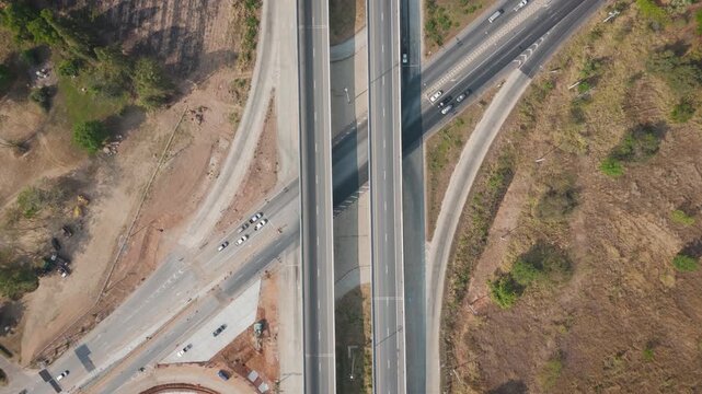Drone footage aerial view scenic landscape of Traffic of many types of vehicles on the highway under construction