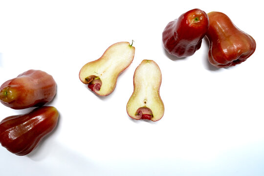 Top view flat lay of wax apples scattered with sliced pieces and large copy space isolated on white background tropical fruit concept