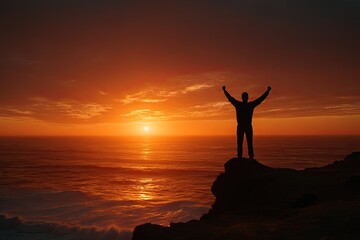Fototapeta premium Silhouette of a person celebrating on a cliff edge at sunset