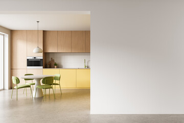 Fototapeta premium Modern kitchen interior with wooden cabinets, yellow cabinetry, dining table set and spacious empty wall space for design display. 3D Rendering