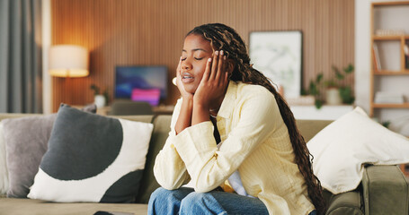 Obraz premium Black woman, headache and stress in home on sofa, exhausted and frustrated with brain fog in living room. Person, fatigue and migraine with chronic pain, burnout and tired with vertigo at house