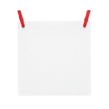 Two red clothespins clipped to the top of a white square cloth