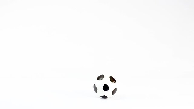 Small Plastic Soccer Ball Bouncing and Rolling on White Background