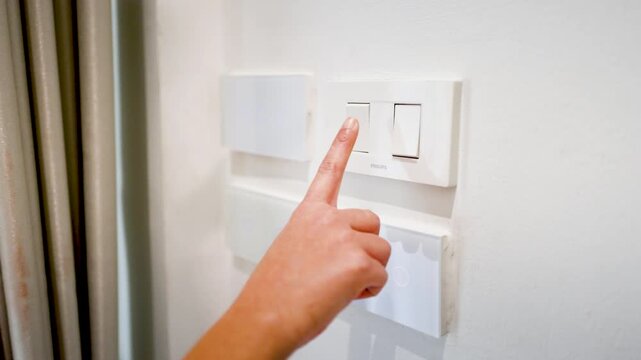 Close Up of Asian Woman Hand Pressing White Light Switch