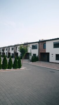 Alternate wide view of townhouse buildings, modern residential architecture complex, urban housing development exterior perspective.

