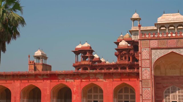 A static shot of the upper facade of Akbar's Tomb, featuring white marble minarets, red sandstone chhatris, and intricate geometric mosaic patterns in Sikandra, Agra