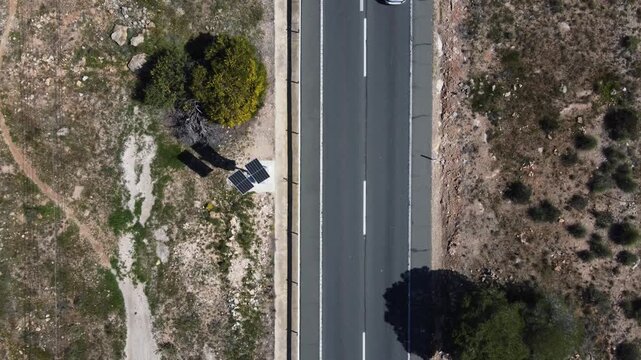 Aerial top view of a solar powered speed trap next to a busy road
