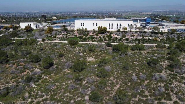 Close aerial approach to a wastewater treatment plant powered by solar panels. EDAR Santa Pola, Spain.