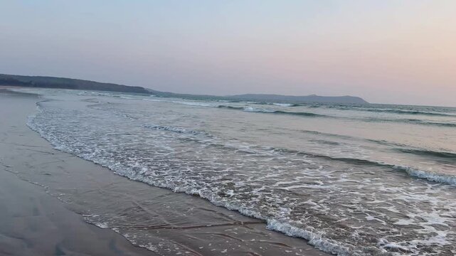 Beautiful 4K view of Aare Ware Beach waves rolling onto the shore. Crystal waters, golden sand, coastal breeze, and scenic Konkan beauty create a peaceful and mesmerizing scene.
