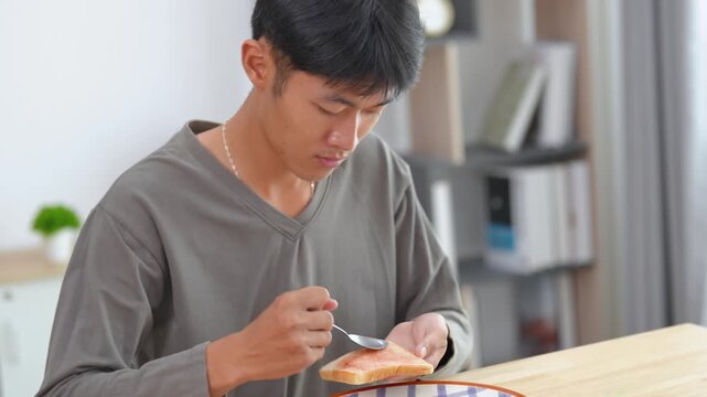 Young man examining a small object with concentration in a cozy indoor workspace featuring a warm atmosphere and modern decor