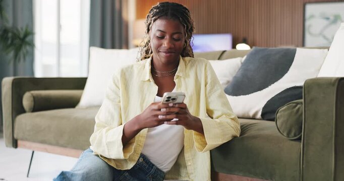 Black woman, phone and smile with texting in home on floor with web chat, notification or online dating. African person, smartphone and typing with mobile app, relax and social network at apartment