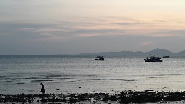 Adult and child walk beside calm sea