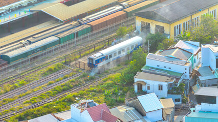 Fototapeta premium An aerial view of Nha Trang Railway Station, Vietnam showcasing a busy transport hub in the heart of the city. Trains line multiple tracks while the station building with its classic architecture