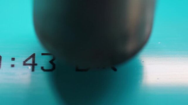 Closeup: Thermal printer burns info onto heavy blue PVC water pipe