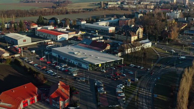 Aerial drone shot around shopping mall with parking lot in hlucin city