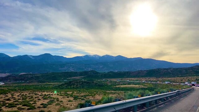 Beautiful golden hour sunset over a mountain scape freeway in California during the month of early April 2026.