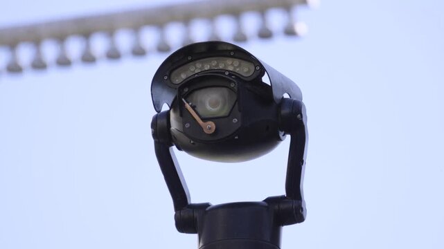 High-Tech Outdoor Surveillance Camera Against Blue Sky. Represents government oversight, public safety, and modern urban security systems. State surveillance, privacy concerns, and monitoring.