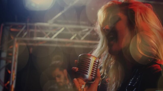 Vertical video: Female singer singing opening note, gripping mic, performing music with guitarist