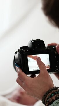 Woman Takes Pictures Of Newborn Baby While Mom Holds Baby Hand. Bright And Warm Setting., Vertical Video, Vertical Video