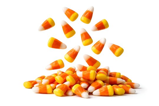 Falling candy corn pieces onto a pile over white background