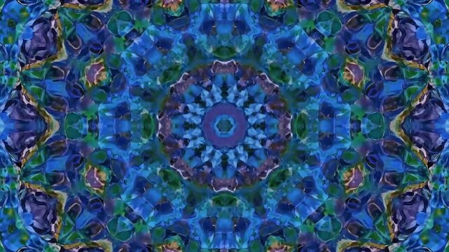 Symmetrical kaleidoscope pattern featuring blues and greens. Floral imagery is present in a centralized mandala design with multiple shapes and layers