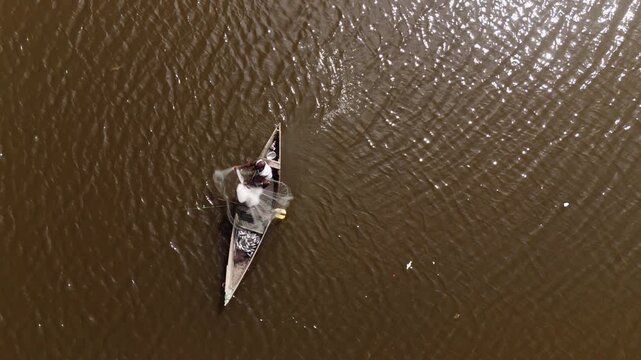 Aerial top view of a traditional fisherman in a wooden boat with his catch in Luanda, Angola